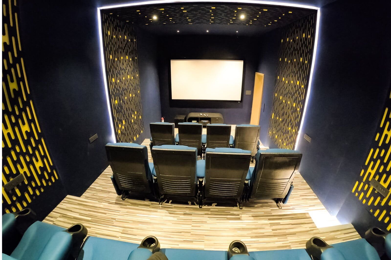 HOME THEATRE – 13 seats, projector on, room dimmed. Composition tight.